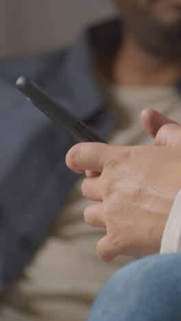 Video-Vertical-De-Amigos-Que-Piden-Comida-Para-Llevar-En-Un-Teléfono-Móvil-Sentados-En-Un-Sofá-En-Casa